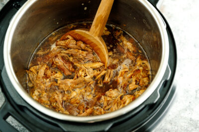The Instant Pot containing juicy and fall-apart tender pulled pork.