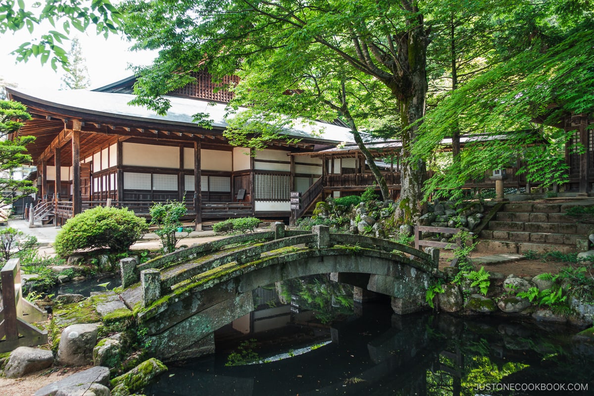 Higashiyama Walking Course stone bridge over a pond with shrine in the background