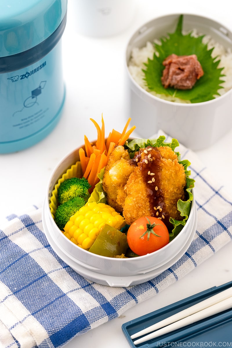 A Zojirushi lunch jar containing steamed rice, chicken katsu, and vegetables.